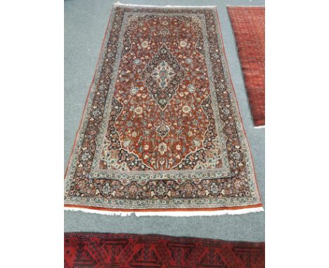 A Kashan carpet on red ground, 136 cm x 258 cm 