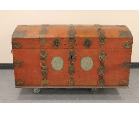 An antique metal bound domed shipping trunk with metal handles 