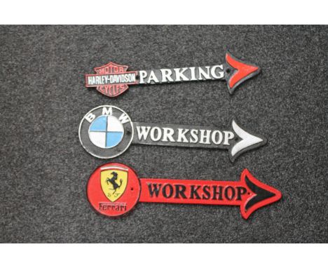 Three cast iron arrows - BMW workshop, Harley Davidson cycle parking and Ferrari workshop 