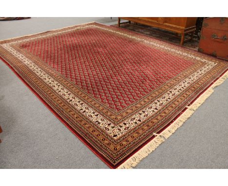 A machine made Turkish carpet on red ground, 420cm by 308cm