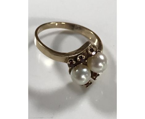 A 9ct gold ring set with two pearls and six small garnets, 3.6g, size O.