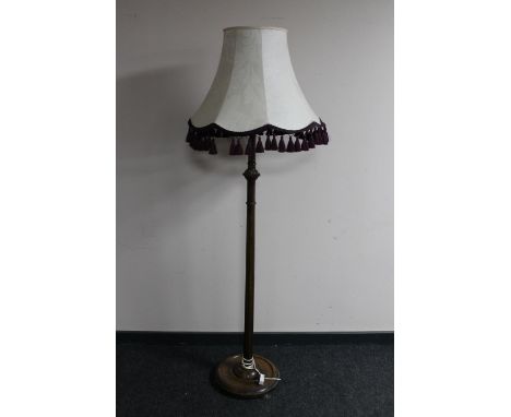 An early 20th century beech standard lamp with tasseled shade 