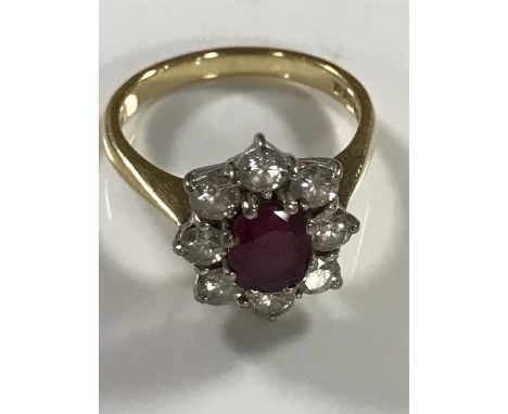 An 18ct gold ruby and diamond cluster ring, approximately 1ct, size N/O.