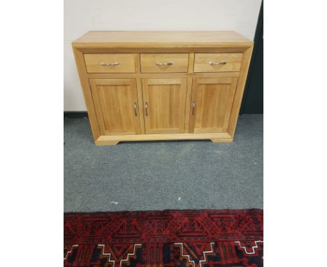 A contemporary light oak sideboard fitted three drawers, width 132 cm 