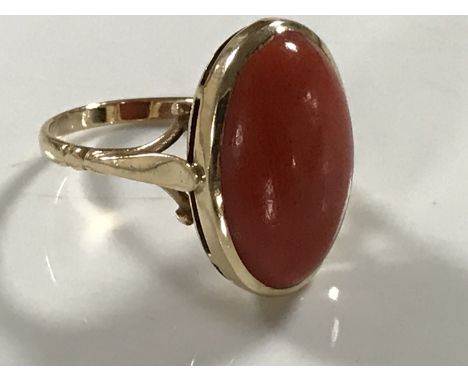 A yellow gold coral ring, 4.6g, size N/O. CONDITION REPORT: Hallmarks rubbed. In good condition. The setting measures 2cm by 