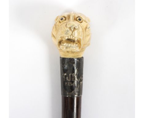 An ebonised walking stick the mount initialled TJB and dated 1934, the horn handle in the form of a strapped terrier/see illu