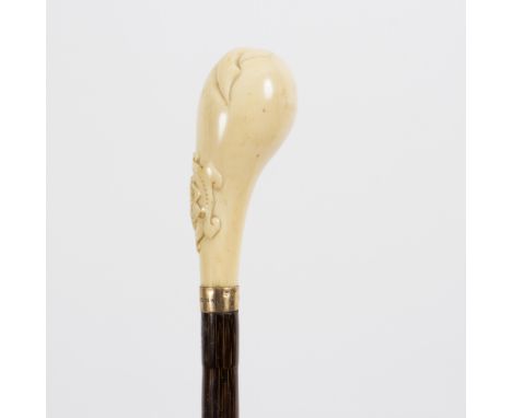 A malacca walking stick, the carved ivory handle in the form of a bud with a monogrammed cartouche and gilt metal collar/see 