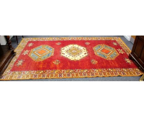 A 20th Century Moroccan red ground carpet, 305cm x 195cm and a similar carpet