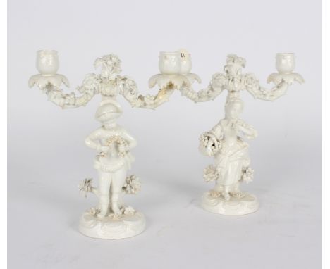 A pair of John Bevington two-branch candelabra, late 19th Century, modelled as a youth and his companion, encrusted with flow