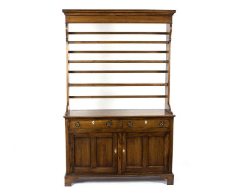 A narrow oak dresser, the open rack above a base of two drawers over cupboards on bracket feet, 127cm wide 