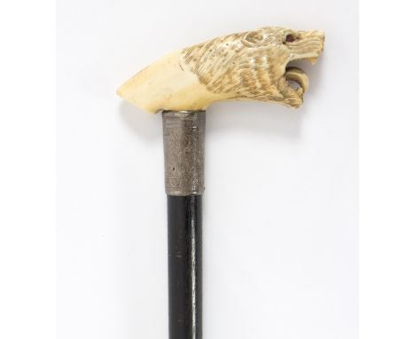 An ebonised walking stick, the carved ivory handle in the form of a roaring lion with engraved mount Condition Report: Lot co