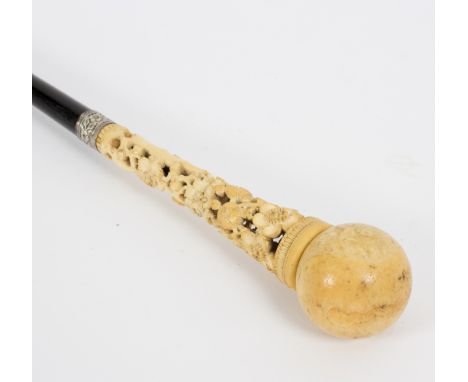 An ebonised walking stick, the ivory ball handle with carved floral support/see illustration Condition Report: Lot contains a