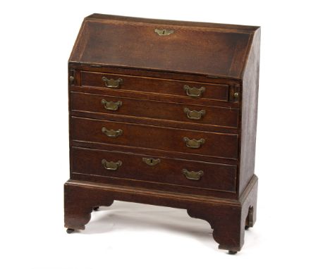 A small oak bureau with four drawers on bracket feet, 61cm wide/Provenance: Beverston Castle