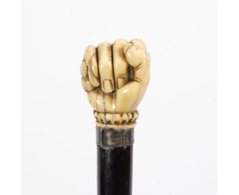 An ebonised walking stick, the carved ivory handle in the form of a clenched fist holding a snake, with plated strap mount Co