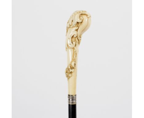 An ebonised walking stick, the carved ivory handle in the form of acanthus scrolls and garlands of flowers and insects Condit