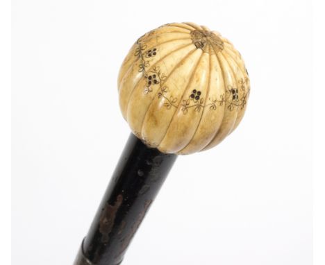 An ebonised walking stick, the ribbed ivory ball handle engraved foliage/see illustration Condition Report: Lot contains an e