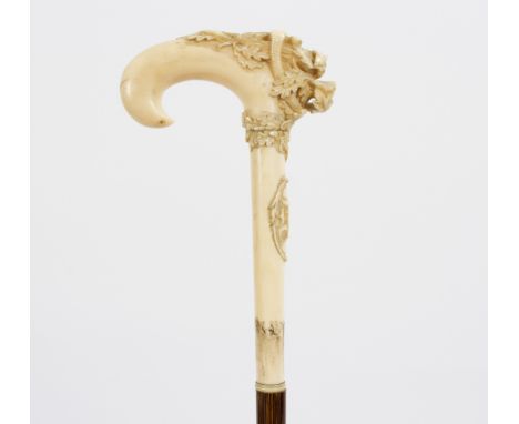 A bamboo walking stick, the ivory handle in the form of a talon, finely carved in relief with a dragon and bird in foliage, m