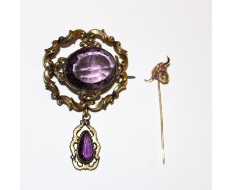 A stick pin with bull's head terminal and a Victorian brooch with purple stone and drop