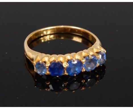 An 18ct gold sapphire five stone ring, the claw set round cut sapphires in a line setting, the centre stone weighing approx 0