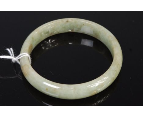A Chinese jade bangle having russet inclusions 42.8g, dia. 7cm