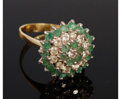 An 18ct gold, emerald and diamond set flower head cluster ring, as a five tier basket setting, 6.2g, size O/P