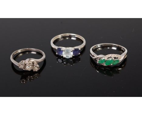 A modern 9ct white gold emerald and diamond point set dress ring by QVC, a 9ct  gold diamond three stone ring, the illusion s