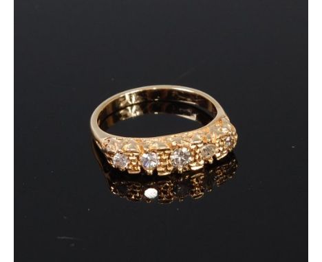 An 18ct gold and diamond set five stone ring, the graduated brilliants in a carved setting, the centre stone weighing approx 