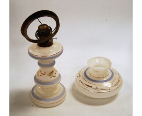 An early 20th century opalescent glass pedestal oil lamp, having gilt decoration