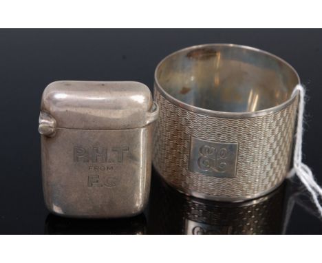 An engine turned silver napkin ring with engraved monogram together with a silver vesta case (2)