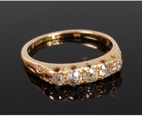 An 18ct gold diamond five stone ring, the graduated old cut diamonds in a chased line setting, total diamond weight estimated