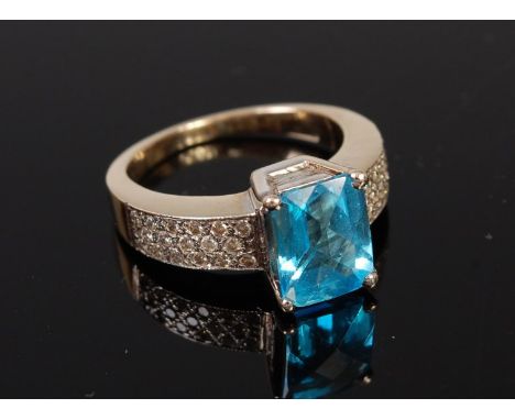 A 14ct gold blue topaz dress ring, the shoulders being pave set with small brilliant cut diamonds, 7g, size J