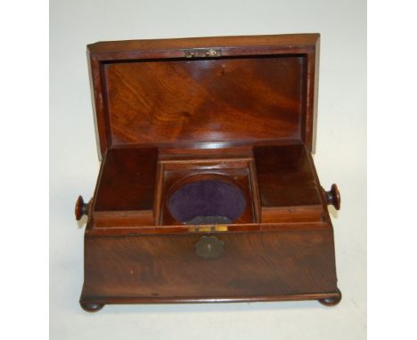 An early Victorian mahogany tea caddy of sarcophagus form having a fitted interior (missing the mixing bowl) and on bun feet,