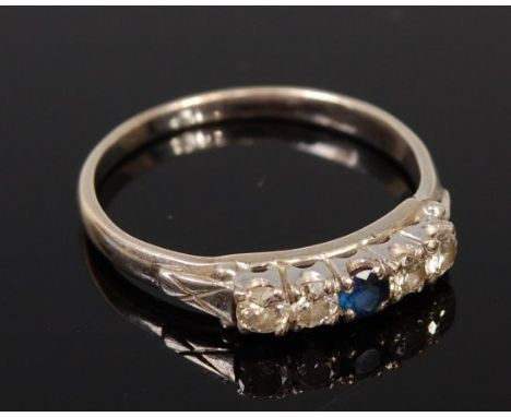 A silver, sapphire and diamond five stone ring, the centre round cut sapphire flanked to either side by a pair of claw set br