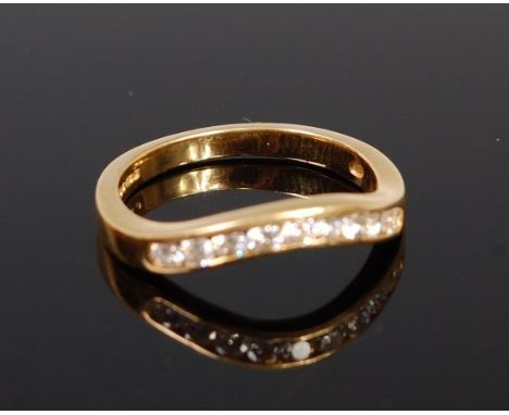 An 18ct gold and diamond set wishbone ring arranged as nine channel set brilliants, total diamond weight estimated approx. 0.