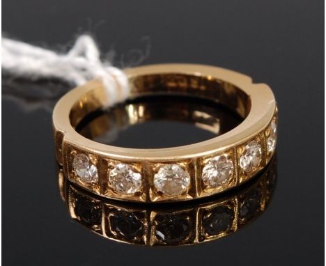 An 18ct gold diamond set half eternity ring arranged as seven illusion set brilliants each weighing approx. 0.1ct, 4.9g, size