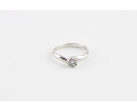 An 18ct. white gold and diamond cross-over style ring,&nbsp;the mount illusion set with single round cut stone to centre surr