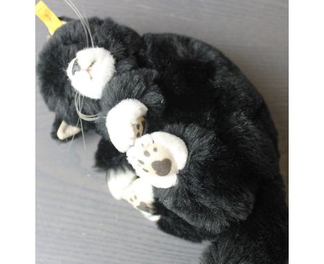 A Steiff sleeping kitten, 074868, black with white nose and paws, with ribbon and ear button.
