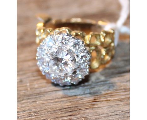 An 18ct. gold and diamond cluster ring, set central round brilliant cut diamond (approx weight 1.15 carats), surrounded borde