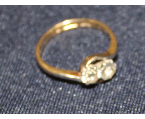 An 18ct. gold and two stone diamond cross-over style ring, set two round old cut diamonds, shank impressed "18ct". (gross wei