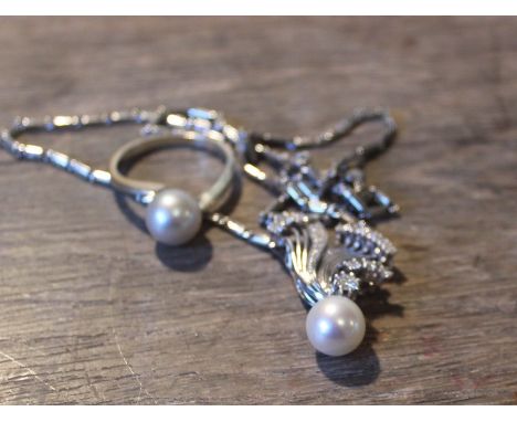 An 18ct. white gold, cultured pearl and diamond pendant choker necklace, fashioned from serpentine wire work, set round brill