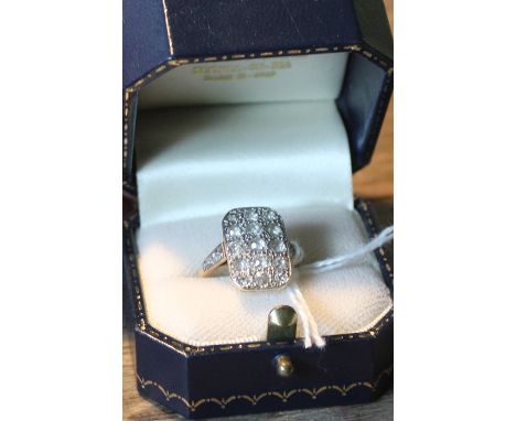 An 18ct. gold and platinum diamond dress ring, pave set fifteen old cut diamonds, shank stamped "18ct. &amp; Plat", (gross we