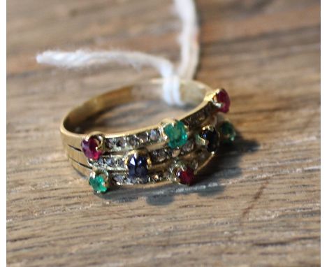 A yellow metal, emerald, ruby, sapphire and rose cut diamond ring, fashioned as three bands merging into one, claw set emeral