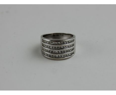 An 18ct. white gold and diamond dress ring, channel set four rows of graduated princess cut diamonds, shank stamped "750". (g