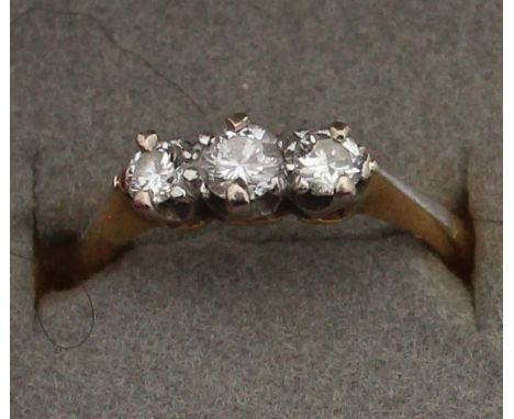 An 18ct. yellow gold and three stone diamond ring, platinum claw set graduated row of three round cut diamonds, shank impress