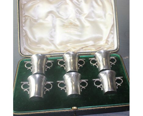 A boxed set of six Edwardian silver whisky tots, by Charles Edwards, assayed London 1905, of traditional reverse tapered circ