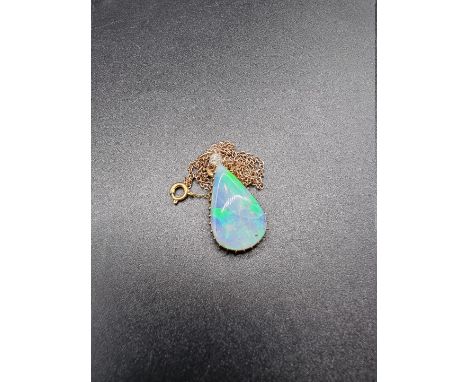 A opal and diamond pendant, in a yellow metal claw setting, 28mm high, with yellow metal chain. 