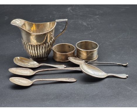 A mixed group of silver, comprising: a cream jug; two caddy spoons; a novelty golf club teaspoon; two napkin rings; and two f