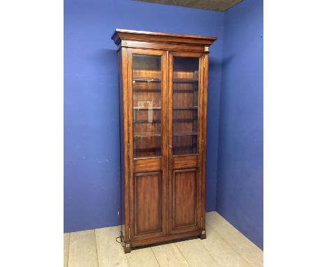 Contemporary glazed bookcase, the glazed doors opening to reveal 3 removable shelves, above a 2 shelved cupboard beneath,  of