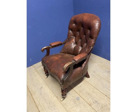 Victorian button back fireside library chair with original rexine or leatheretteupholstery, on turned legs with ceramic casto