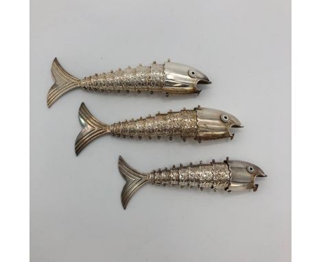 Three graduated white metal articulated fish ornament, with glass enamel eyes marked Mexico, approx 425g 